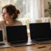 Person comparing three laptops on a desk before buying their first laptop