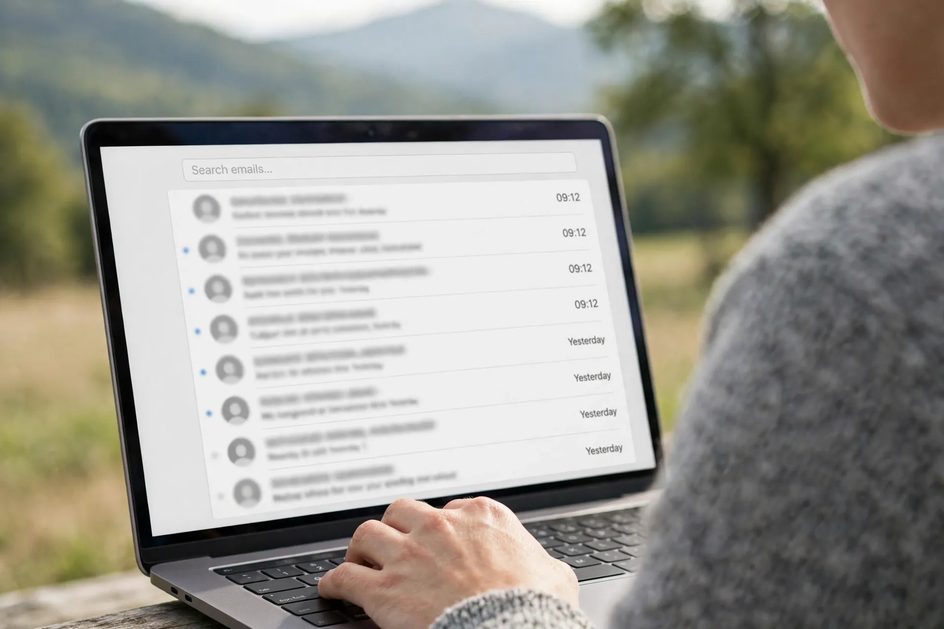 Close-up of a laptop screen showing a generic email inbox with a search bar, used to find old signup and welcome emails